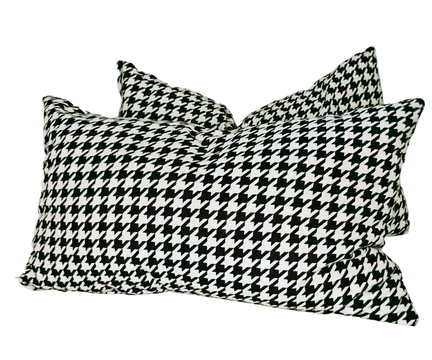 Two black and white houndstooth patterned pillows on a white surface.
